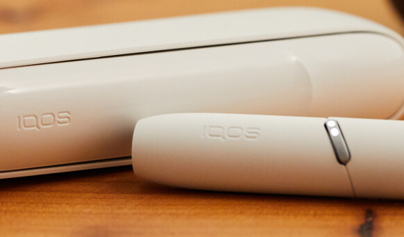 IQOS 3 DUO em Vermelho Geada ao lado de caixa de presente vermelha
